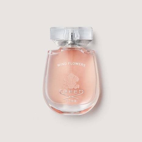 windflowers bottle with glass stopper showing pink liquid in a curved bottle