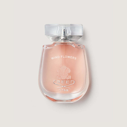 windflowers bottle with glass stopper showing pink liquid in a curved bottle